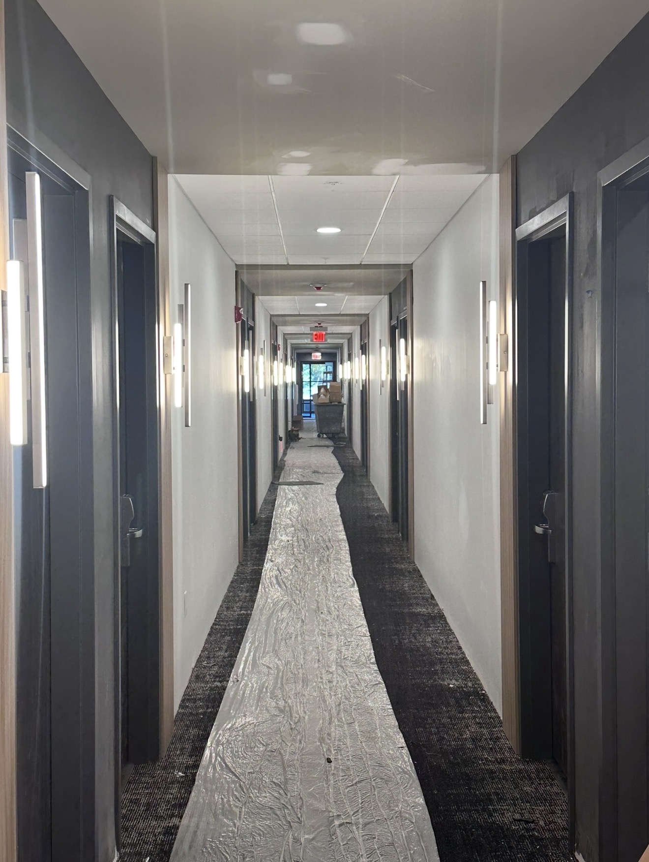 Multifamily corridor with completed architectural and egress lighting installation